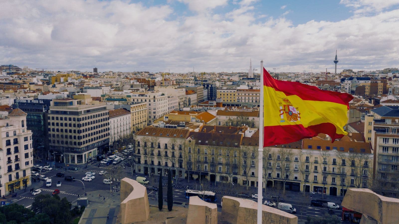 Bandeira da Espanha hasteada sobre Madri, com a cidade vista do alto
