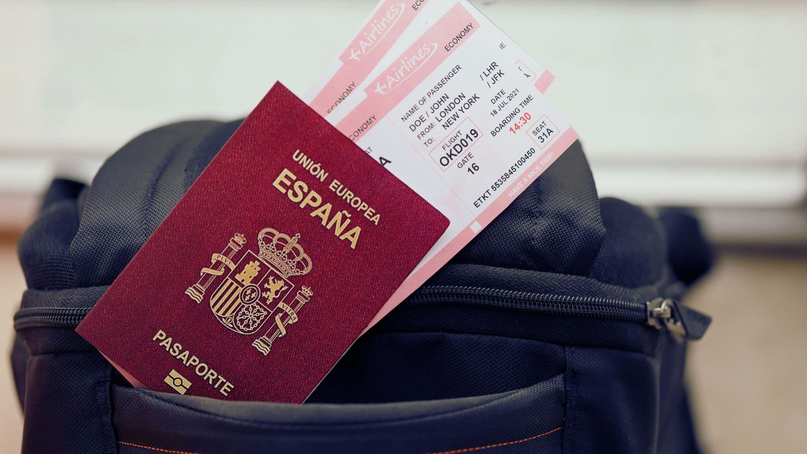 Passaporte espanhol com cartões de embarque, apoiado sobre uma mochila