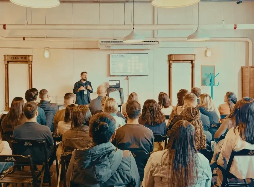 A equipe da Você Europeu reunida num encontro interno, diante de um apresentador