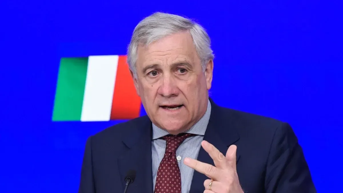 Antonio Tajani, ministro das Relações Exteriores da Itália, falando e gesticulando diante da bandeira italiana