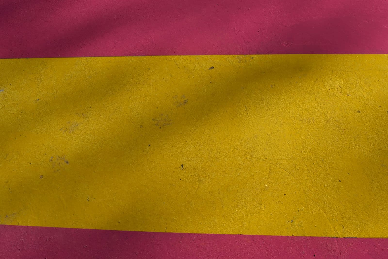 Faixas vermelha e amarela da bandeira da Espanha em close, ocupando todo o quadro